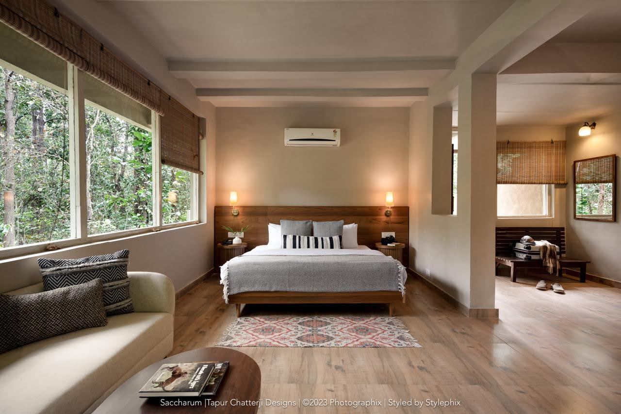 A bright lodge room with large windows onto the forest