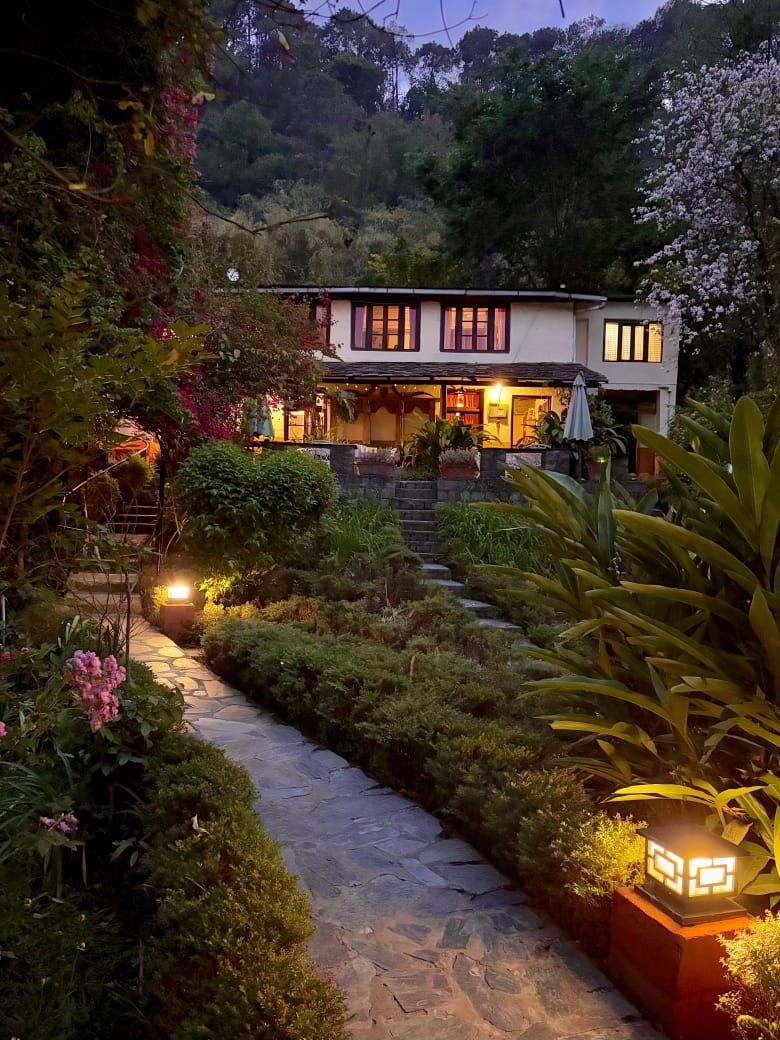The garden path and main house lit up in the evening
