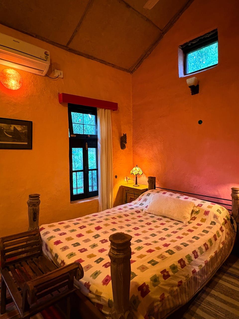 A warm, colourful guest room in a traditional mud house